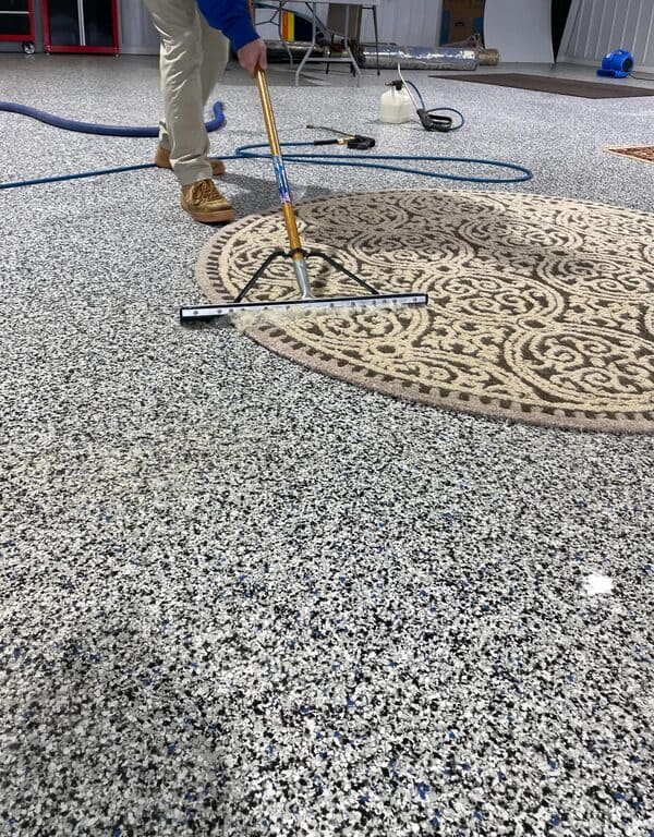 Worker at Pro-Master Cleaning & Restoration cleaning a rug with equipment