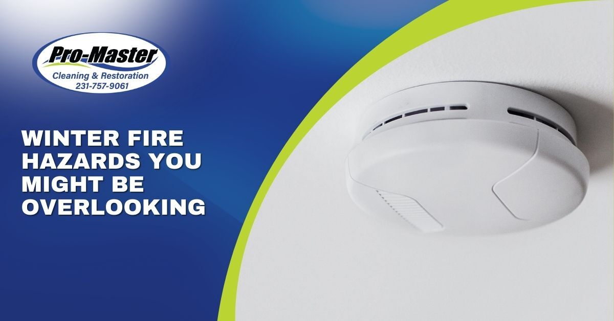 Smoke alarm on a Pro-Master branded blue and green templated background with text "Winter Fire Hazards You Might Be Overlooking"