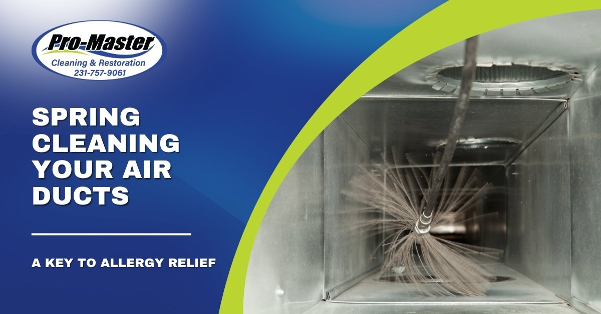 Promotional graphic for Pro-Master Cleaning & Restoration featuring the text 'Spring Cleaning Your Air Ducts: A Key to Allergy Relief' on a blue background. The right side shows a close-up of a circular cleaning brush inside a metal air duct, removing dust and debris, with a green curved stripe dividing the sections.
